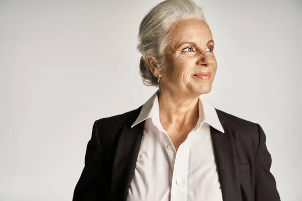 Business portrait of happy middle aged businesswoman in white shirt and blazer looking away — Stock Photo