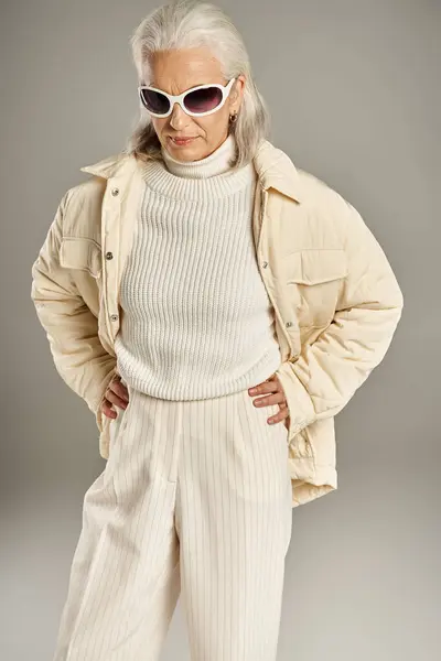 Belle et grise femme d'âge moyen en tenue élégante posant sur fond gris — Photo de stock