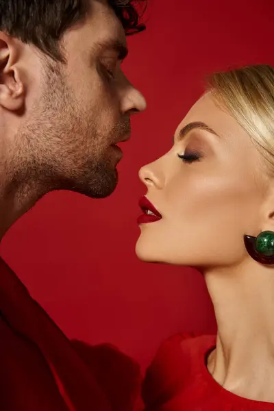Side view of good looking man posing with beautiful blonde woman with red lips on vibrant background — Stock Photo