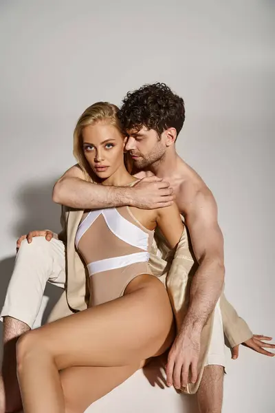 Hemdlos schöner Mann umarmt schöne blonde Frau in beigem Blazer und Body, sexy Paar — Stockfoto