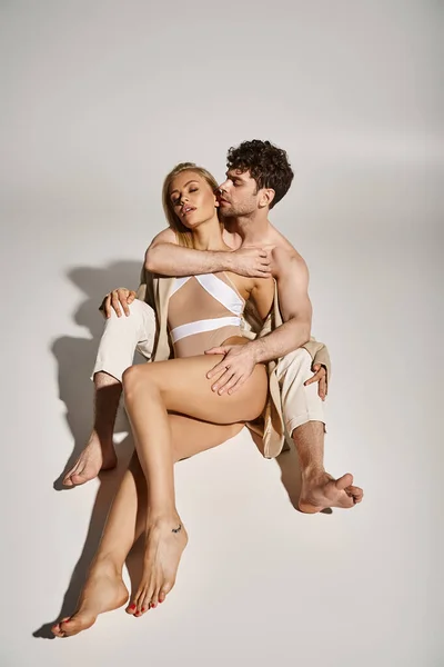 Hemdlos schöner Mann umarmt charmante blonde Frau in beigem Blazer und Body, sexy Paar — Stockfoto
