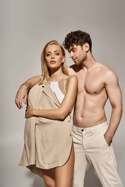 Hemdloser Mann mit Hand in Tasche legt Hand auf Schulter der blonden Frau im Body und Blazer — Stockfoto