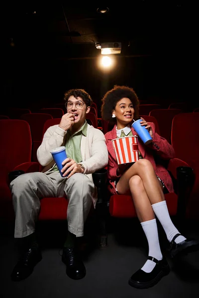 Joyous young multiethnic couple in retro attires enjoying their date at cinema on Valentines day — Stock Photo