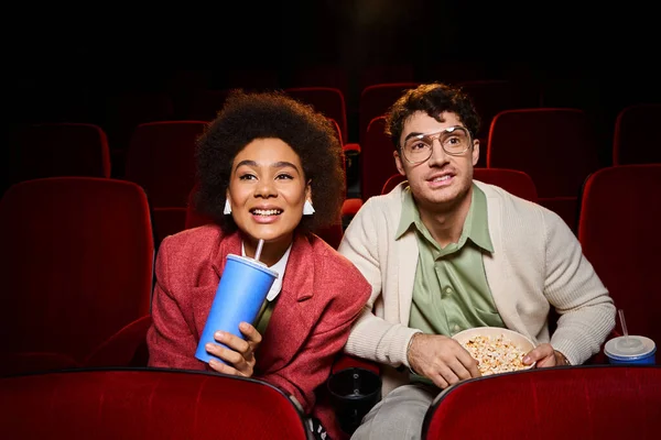 Fröhliches junges, vielseitiges Paar in trendigen Klamotten, Film guckend und lächelnd im Kino, Valentinstag — Stockfoto