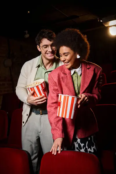 Happy appealing diverse couple enjoying their date and smiling sincerely at cinema, Valentines day — Stock Photo