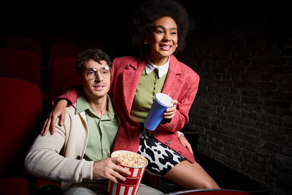 Fröhliche multiethnische Paar in stilvoller Kleidung genießen ihr Date im Kino, Valentinstag — Stockfoto