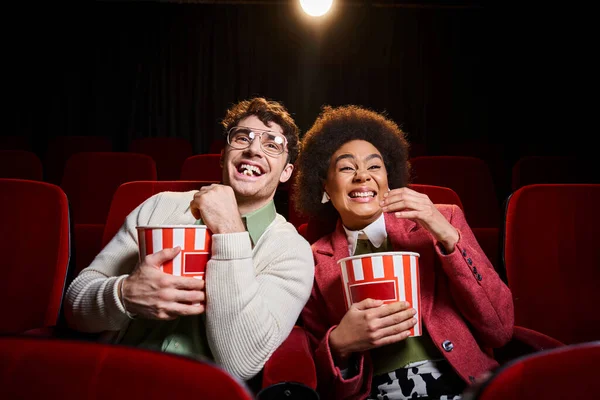 Cheerful young multicultural couple in retro attires enjoying their date at cinema on Valentines day — Stock Photo
