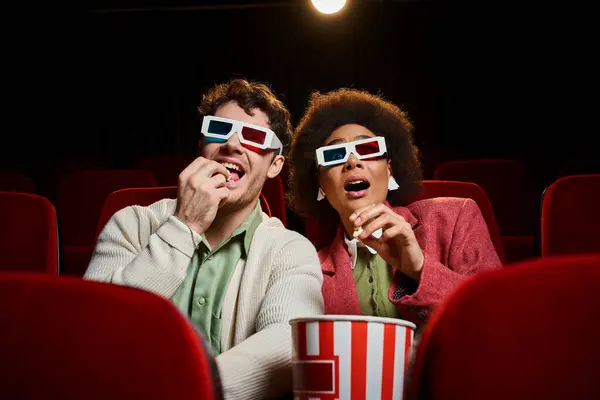 Шокированная африканская американка, сидящая рядом со своим веселым парнем в кино на свидании, в День Святого Валентина — стоковое фото