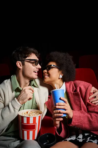 Joyful multicultural couple in retro attires smiling joyfully at each other on date at cinema — Stock Photo
