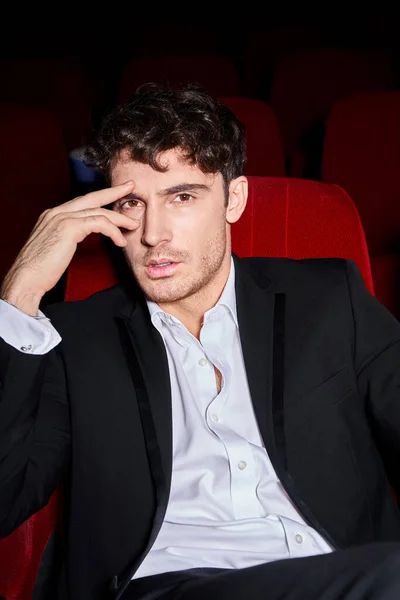 Appealing elegant male model in  black chic suit spending time at cinema and looking at camera — Stock Photo