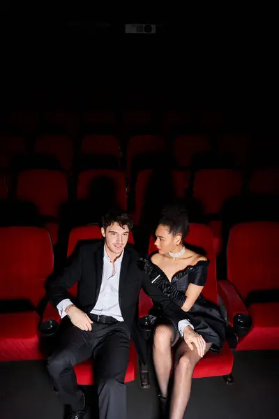 Good looking multiracial couple in stylish clothing watching movie at cinema on date, Valentines day — Stock Photo