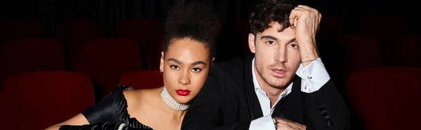Young diverse couple in evening attires at cinema on date looking at camera, Valentines day, banner — Stock Photo
