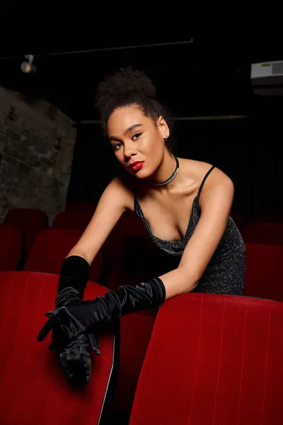 Appealing young african american woman with red lipstick in evening black dress looking at camera — Stock Photo