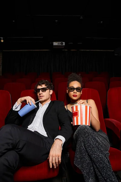 Alluring young interracial couple with 3d glasses watching movie on date at cinema, Valentines day — Stock Photo
