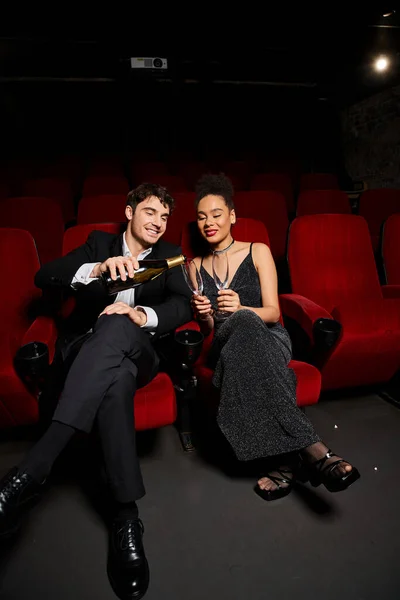 Glückliches junges, vielseitiges Paar in eleganter Kleidung genießt Date mit Champagner im Kino, Valentinstag — Stockfoto