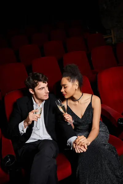 Alluring beautiful diverse couple in evening attires clinking champagne glasses on Valentines day — Stock Photo