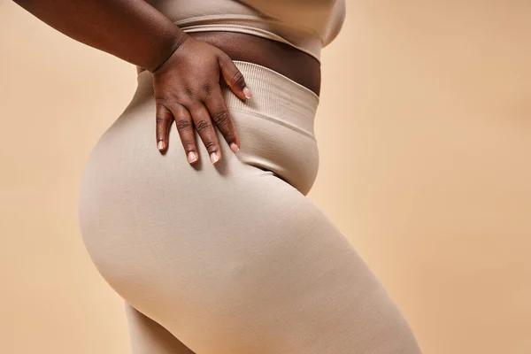 Cropped view of plus size african american woman in underwear posing on beige backdrop, curvy body — Stock Photo