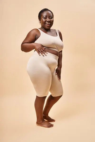 Selbstbewusste Plus-Size-Frau in beiger Unterwäsche posiert mit verschränkten Armen, positivem Körper und Selbstwertgefühl — Stockfoto