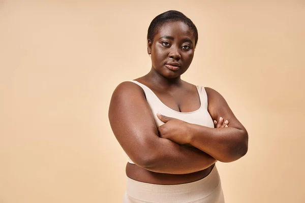 Plus size woman in beige underwear posing with crossed arms, body positive and self esteem — Stock Photo