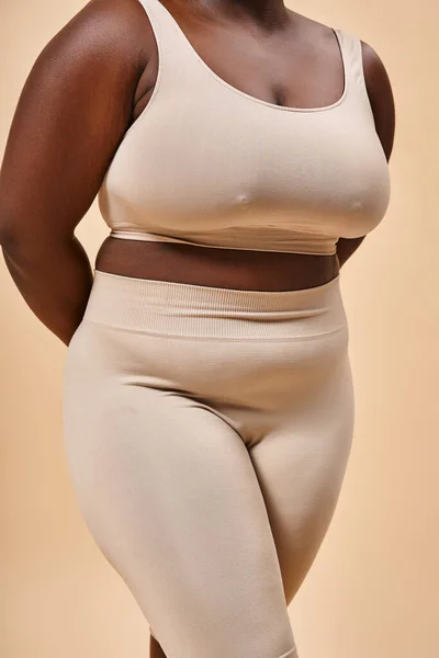 Обрізана плюс розмір жінка в бежевій білизні позує в студії, тіло позитивне і самоповажне — стокове фото
