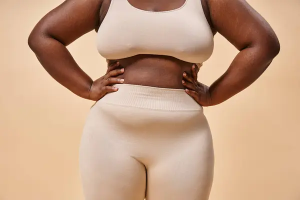 Cropped plus size woman in underwear posing on beige backdrop, body positive and female empowerment — Stock Photo