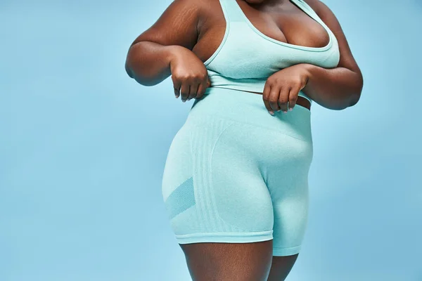 Подробный снимок plus size женщины в байкерских шортах на синем фоне, позитивный для тела — стоковое фото