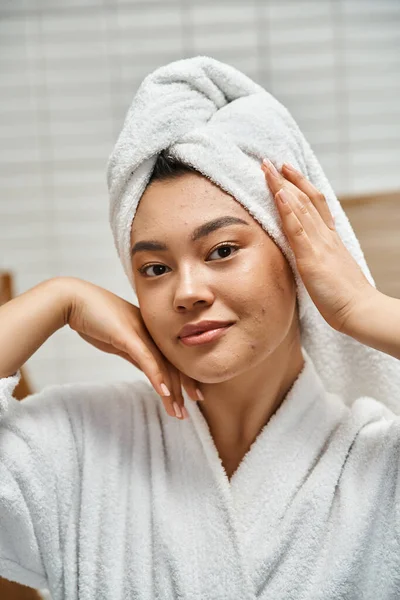Plan vertical de jeune femme asiatique avec la peau sujette à l'acné avec serviette blanche sur la tête dans la salle de bain — Photo de stock
