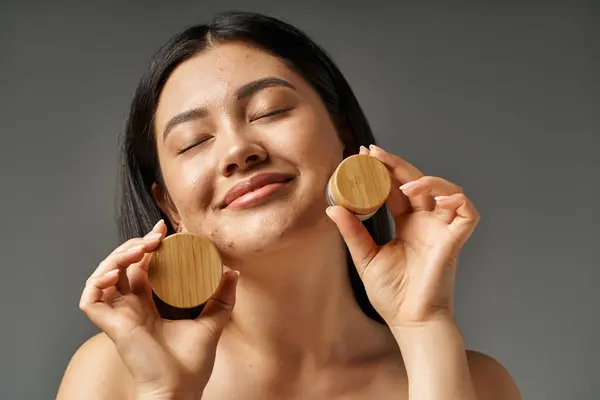 Mujer asiática joven con pelo morena y piel propensa al acné mirando el espejo en el baño, pancarta - foto de stock