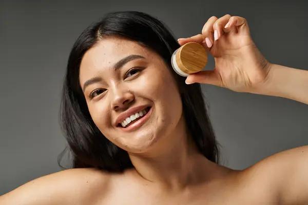 Young asian woman with brunette hair and acne prone skin looking at mirror in bathroom, banner — Stock Photo