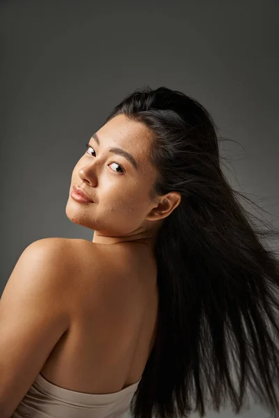 Jeune femme asiatique avec des cheveux bruns et l'acné peau sujette à regarder miroir dans la salle de bain, bannière — Photo de stock