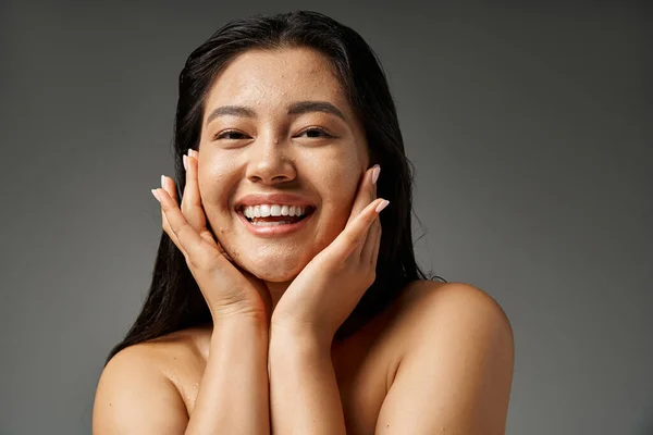 Giovane donna asiatica con capelli castani e pelle incline all'acne guardando specchio in bagno, banner — Foto stock