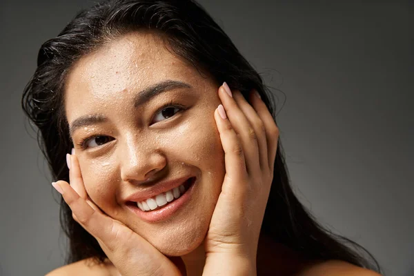 Giovane donna asiatica con capelli castani e pelle incline all'acne guardando specchio in bagno, banner — Foto stock