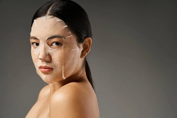 Giovane donna asiatica con capelli castani e pelle incline all'acne guardando specchio in bagno, banner — Foto stock