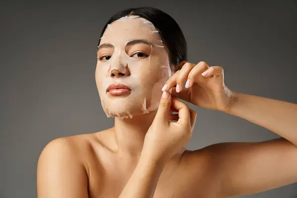 Young asian woman with brunette hair and acne prone skin looking at mirror in bathroom, banner — Stock Photo