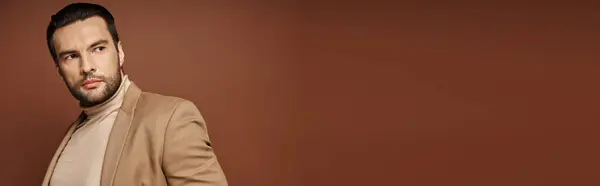 Bel homme en tenue élégante regardant loin tout en posant en blazer sur fond beige, bannière — Photo de stock