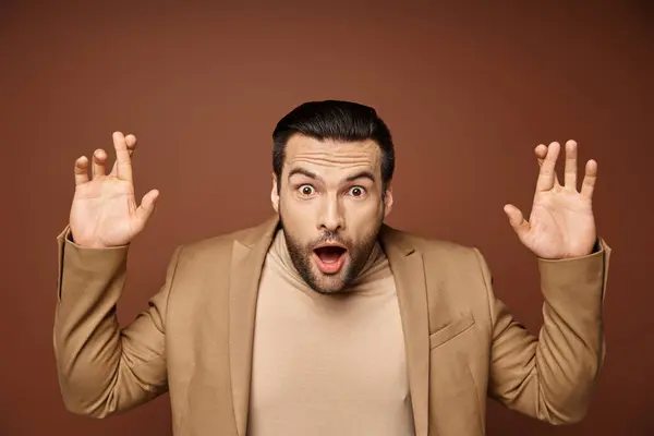Astonished man in elegant attire with his fingers crossed showing excitement on beige background — Stock Photo