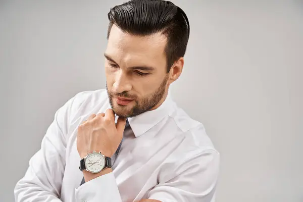 Portrait of serious businessman in white shirt and tie posing with confidence on grey background — Stock Photo