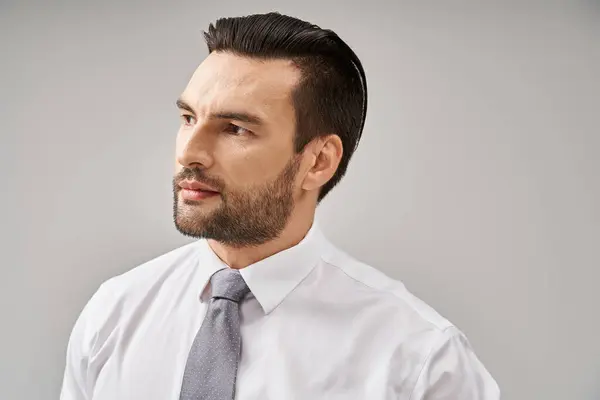 Portrait d'homme d'affaires élégant en chemise blanche et cravate posant avec confiance sur fond gris — Photo de stock