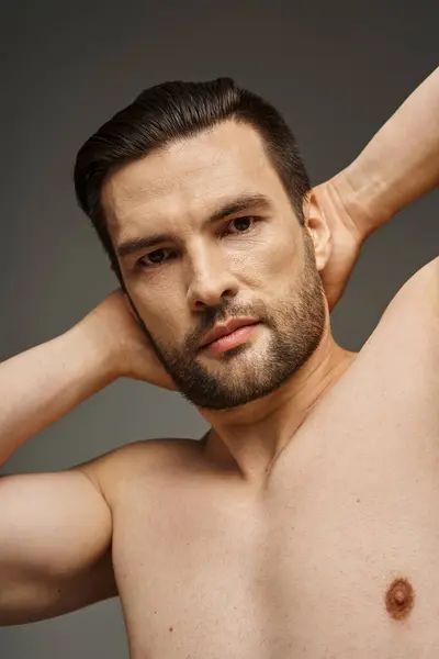 Portrait d'un homme musclé et torse nu à la poitrine et aux poils posant sur fond gris — Photo de stock