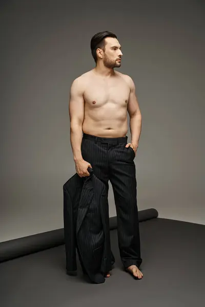 Homme brune dans la trentaine posant avec la poitrine nue en costume de pinstripe et tenant blazer, main dans la poche — Photo de stock