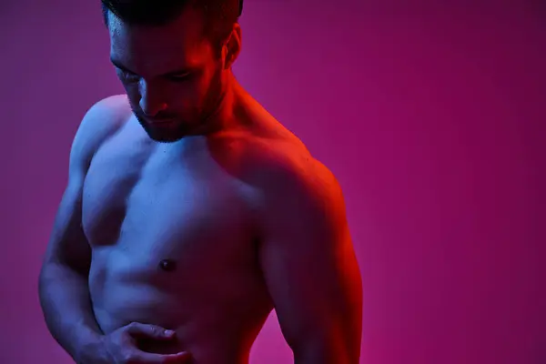 Portrait of seductive man with bristle and bare chest posing on purple backdrop with lights — Stock Photo
