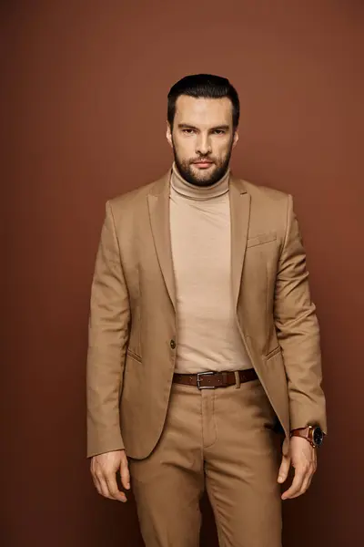 Portrait d'homme confiant et beau avec soies en costume élégant posant sur fond beige — Photo de stock