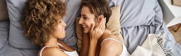 Top view banner, happy african american lesbian woman with curly hair lying in bed with girlfriend — Stock Photo