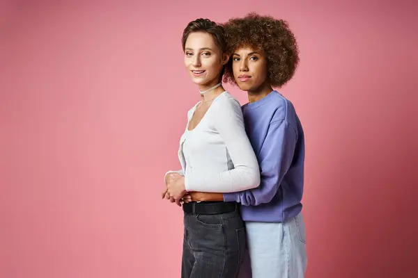Happy african american woman embracing her girlfriend on pink background, lgbtq couple love — Stock Photo
