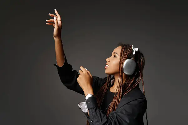 Sorrindo mulher afro-americana com dreadlocks ouvir música em fones de ouvido e olhando para longe — Fotografia de Stock