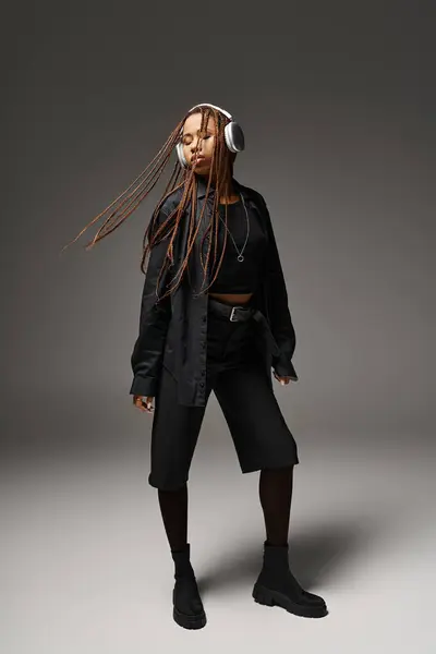 Молодая африканская американская девушка 20 лет с дредами, слушающая музыку в наушниках, экстатический танец — стоковое фото