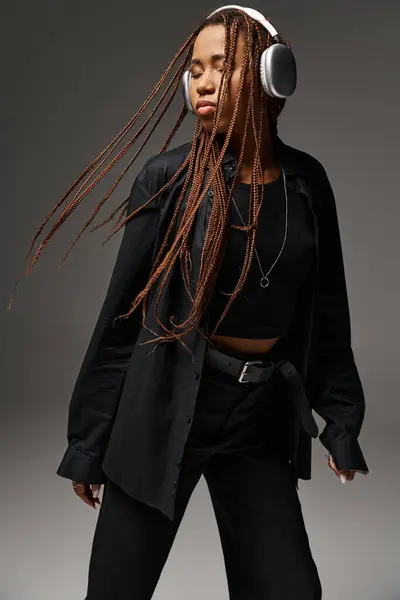 Африканская американская девушка в возрасте 20 лет с дредами прослушивания музыки в наушниках, экстатический танец — стоковое фото