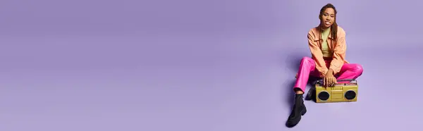 Bannière de heureuse femme afro-américaine avec dreadlocks assis près boombox rétro sur fond violet — Photo de stock