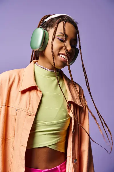 Jolly african american girl in 20s listening music in wireless headphones, moving to rhythm, dance — Stock Photo