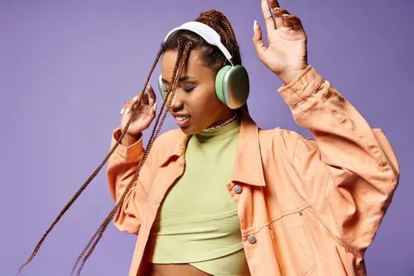 Pleased african american girl in 20s listening music in wireless headphones, moving to rhythm — Stock Photo